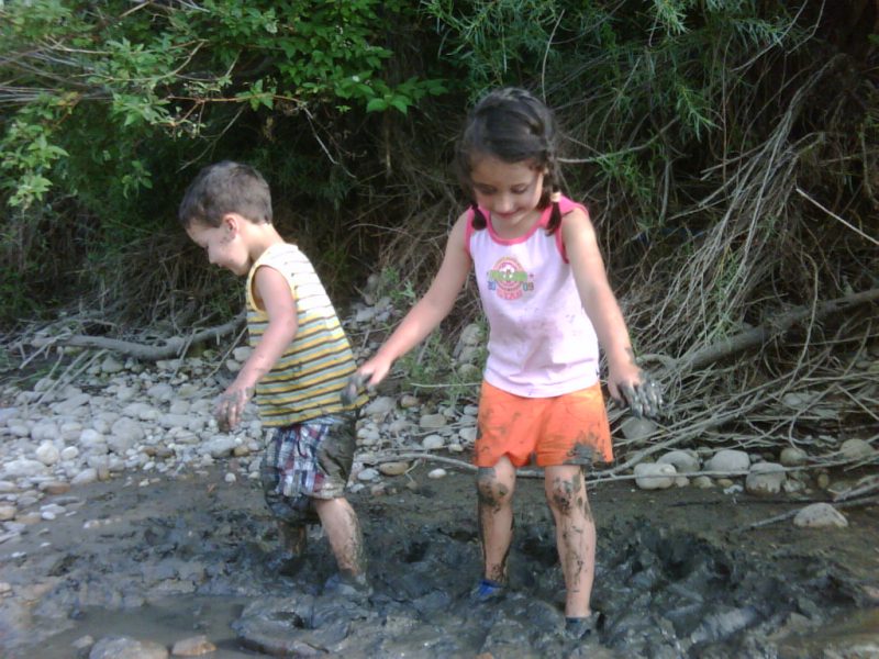 Helen y Billy jugando en el lodo junto al río Bow en el Parque Provincial Wyndham Carseland