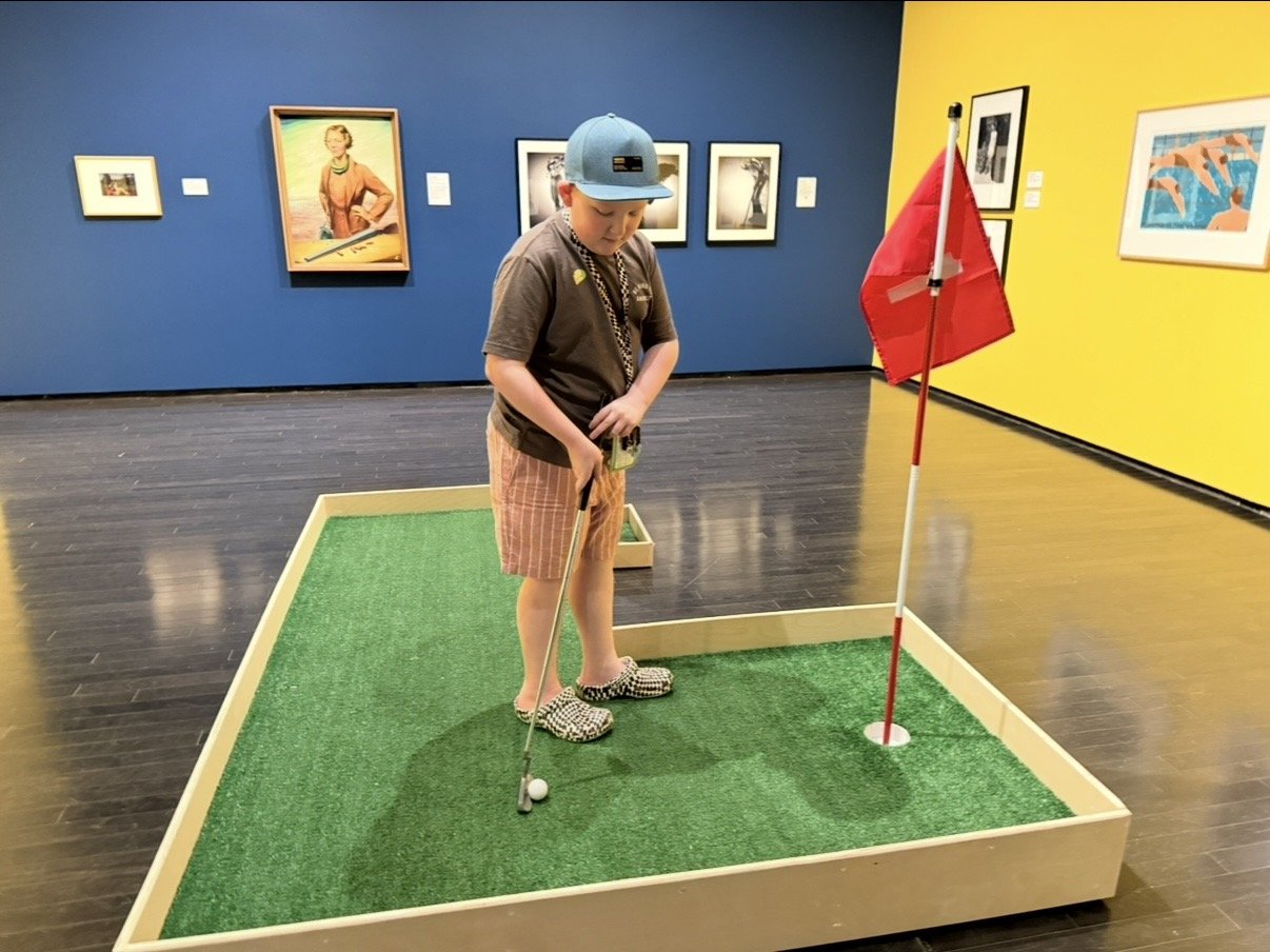 Boy Playing Mini-Golf in Art Gallery