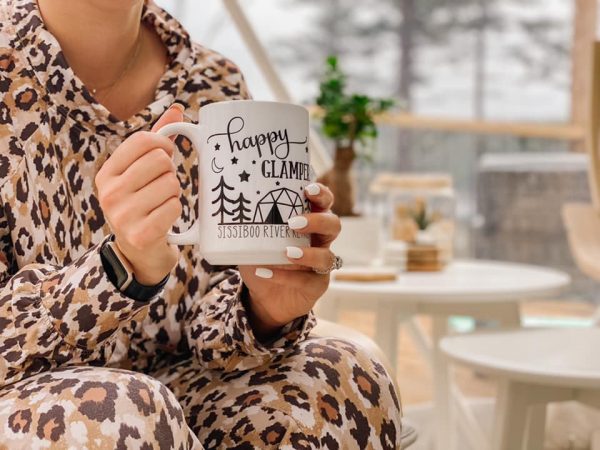 Mädchen im Pyjama wiegt eine köstliche Tasse heiße Schokolade im Sissiboo River Retreat in Weymouth, Nova Scotia