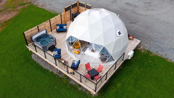 Vue extérieure à vol d'oiseau du dôme géodésique du Valley Sky Glamping montrant la terrasse et le bain à remous