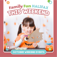 A girl with a pumpkin tshirt on is smiling while doing Halloween-themed crafts