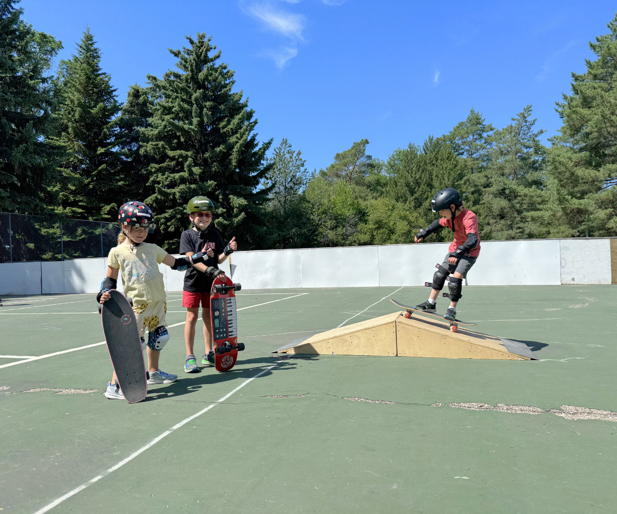 Right to Skate Summer Camps - Kids Holding skateboard. One on a Ramp in rink
