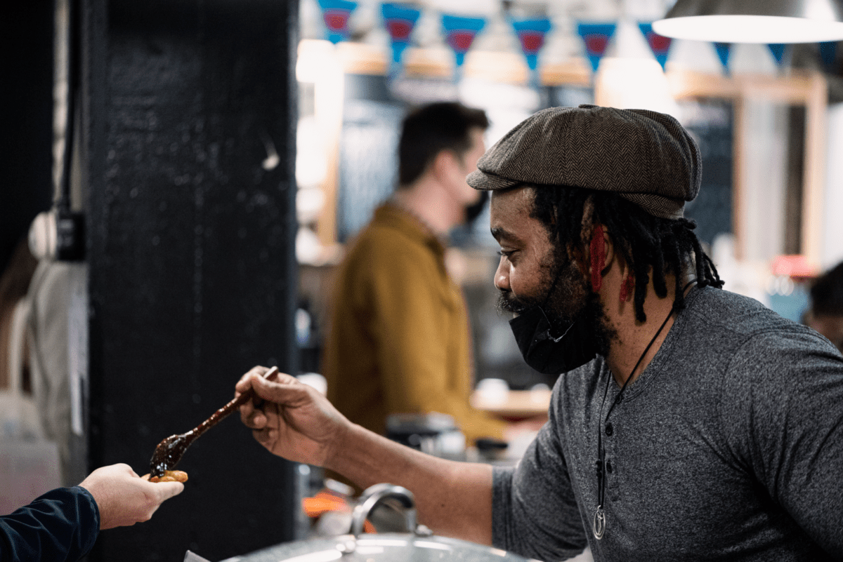 A man offers a customer a sample of jelly or chutney at the Halifax Brewery Market, first stop on the Settled Nomads Tour on Nova Scotia's Eastern Shore