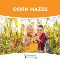 Girl and woman holding corn in a corn field.