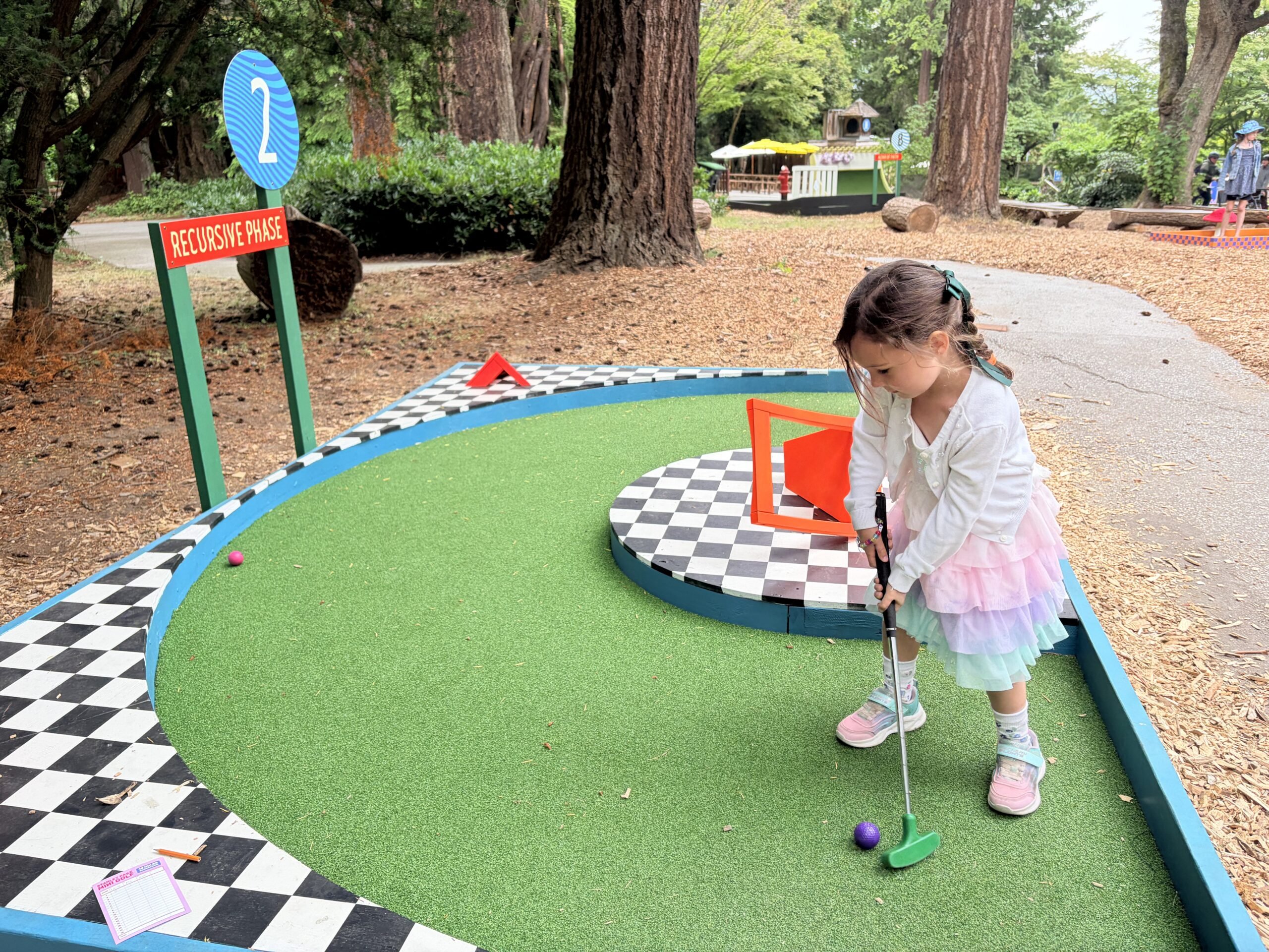 Mia putting at Stanley Park Mini Golf