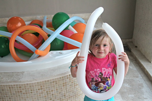 Mi hija mostrándome lo grande que era su sonrisa. ¡Le encantó su baño de globos!