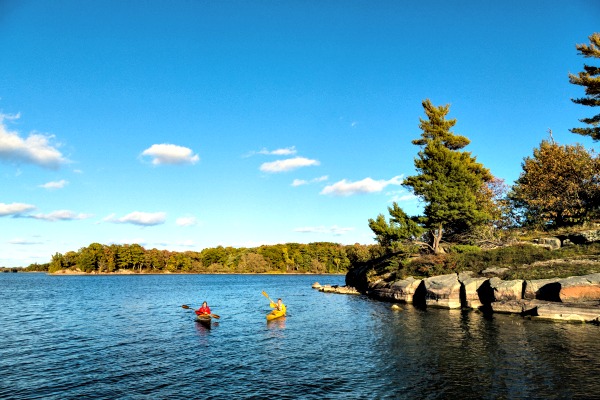 Un jeune couple en kayak, se rend à leur camping aux Mille-Îles