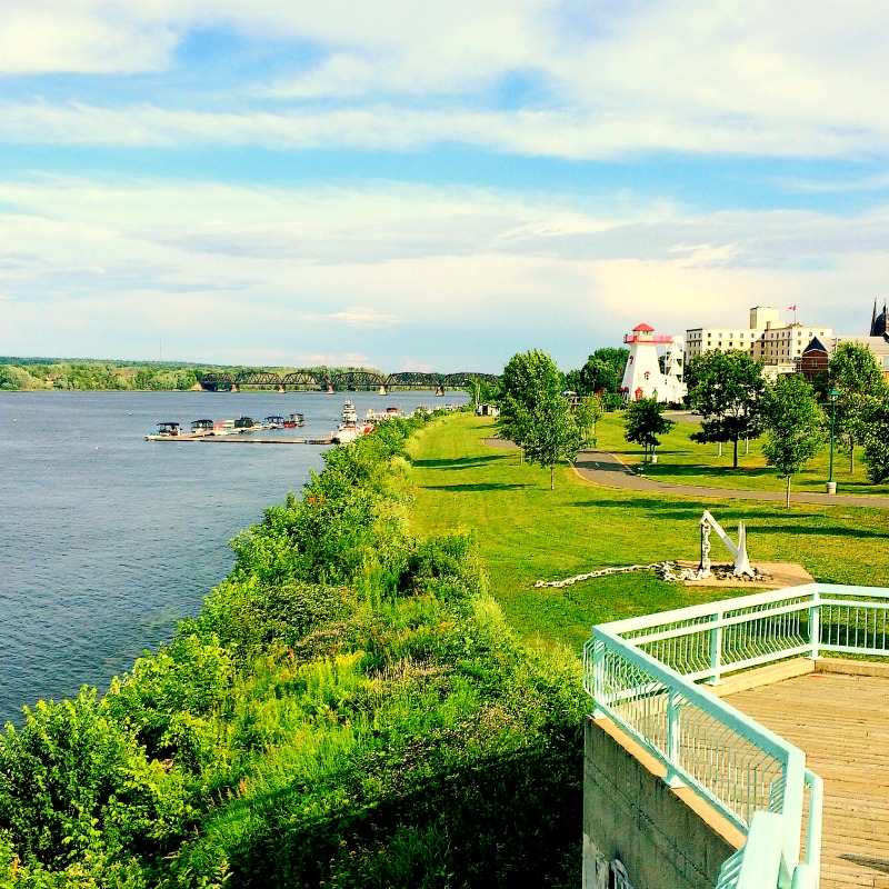 Uma vista do Riverwalk de Fredericton com o Farol e Crowne Plaza