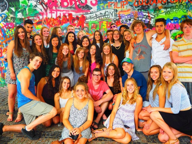 Smiling MEI International students at the Lennon Wall