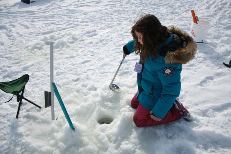 Ice Fishing at Village Nordik in Quebec City scooping ice