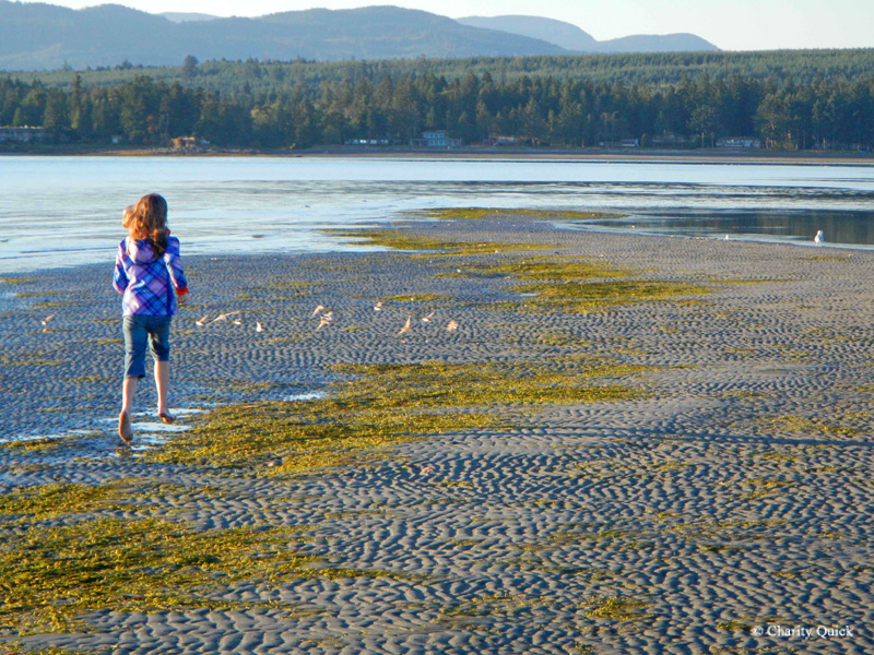 Chica corriendo en la playa en Rathtrevor Beach Provincial Park Credit Charity Quick)