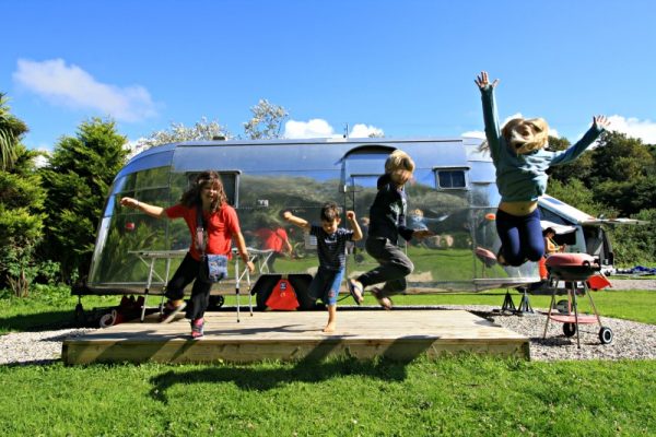 Airstream Safari 1956 niños saltando en Coastal Valley and Crafts Campground, Newquay Cornwall foto de Helen Earley