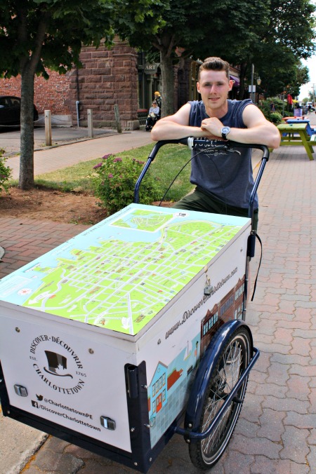 В Шарлоттауне студенты ездят на велосипеде по Шарлоттауну с картами для туристов. Хороший!