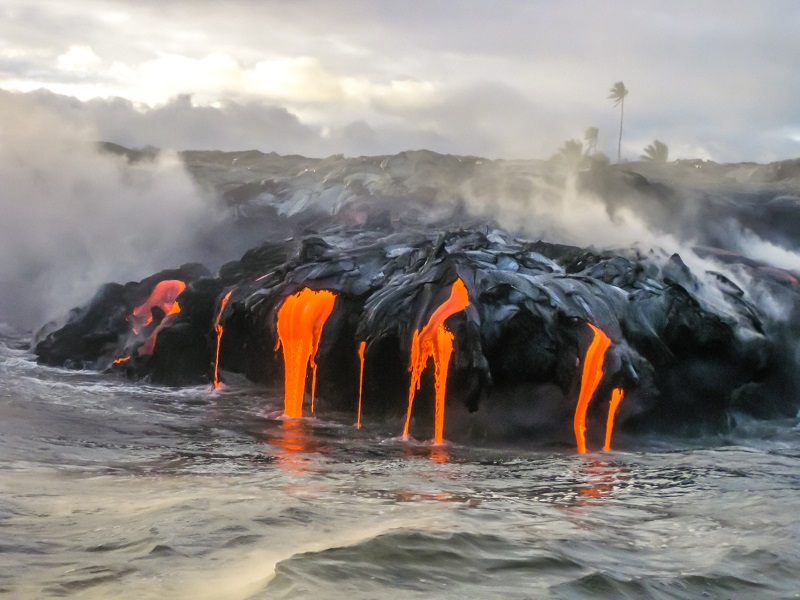 アメリカ合衆国、ハワイ島、キラウエア火山の海の景色。 1983年から操業している落ち着きのない火山。溶岩が海に飛び込むように暗闇で光る日没時に撮影されたショット。