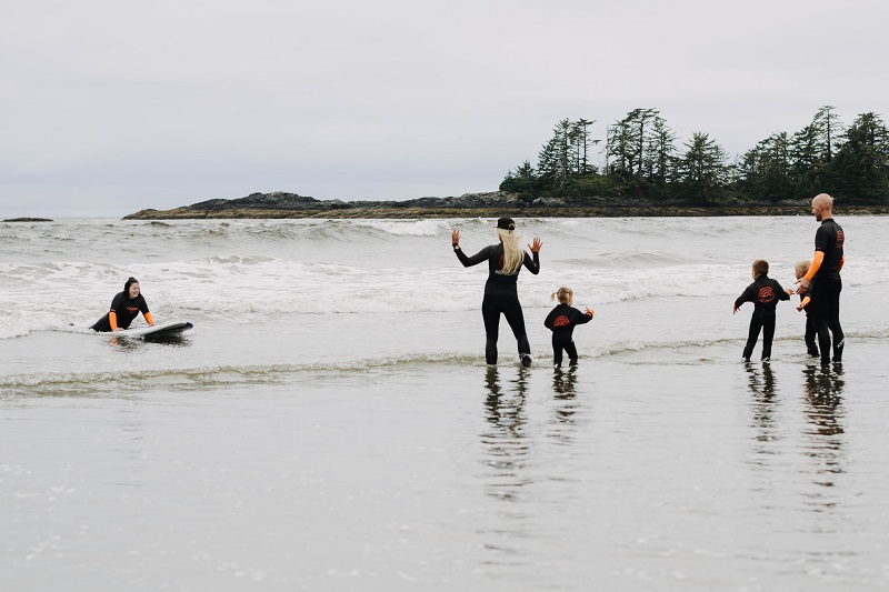 Mom riding the waves in Tofino Bracey Photography
