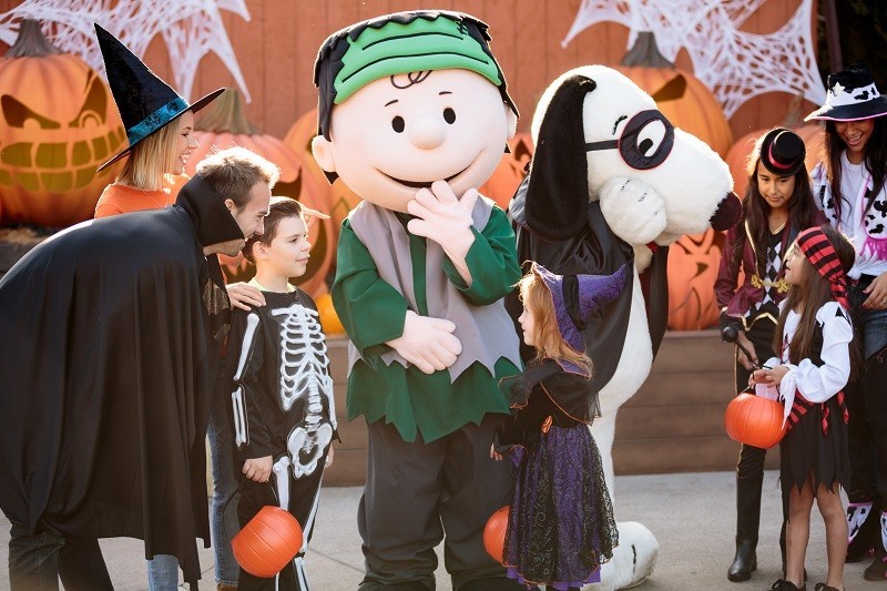 Families meet Snoopy and Charlie Brown in front of pumpkins. Photo Knott's Spooky Farm