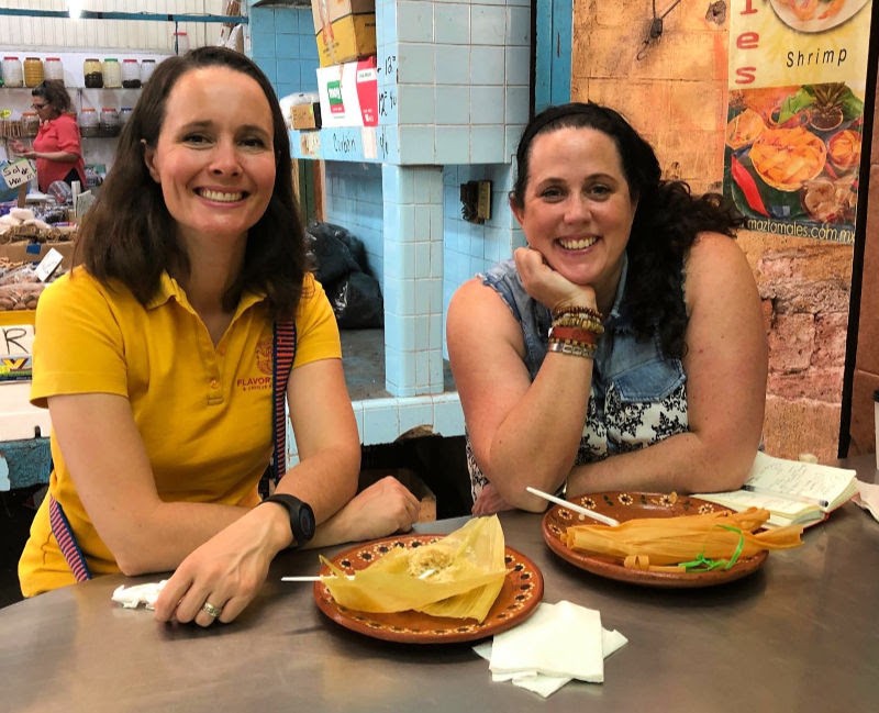 Reiseleiterin Maikke Hoekstra und hungrige Touristin Helen Earley genießen Tamales auf dem Markt von Pino Suarez in Mazatlan, Mexiko