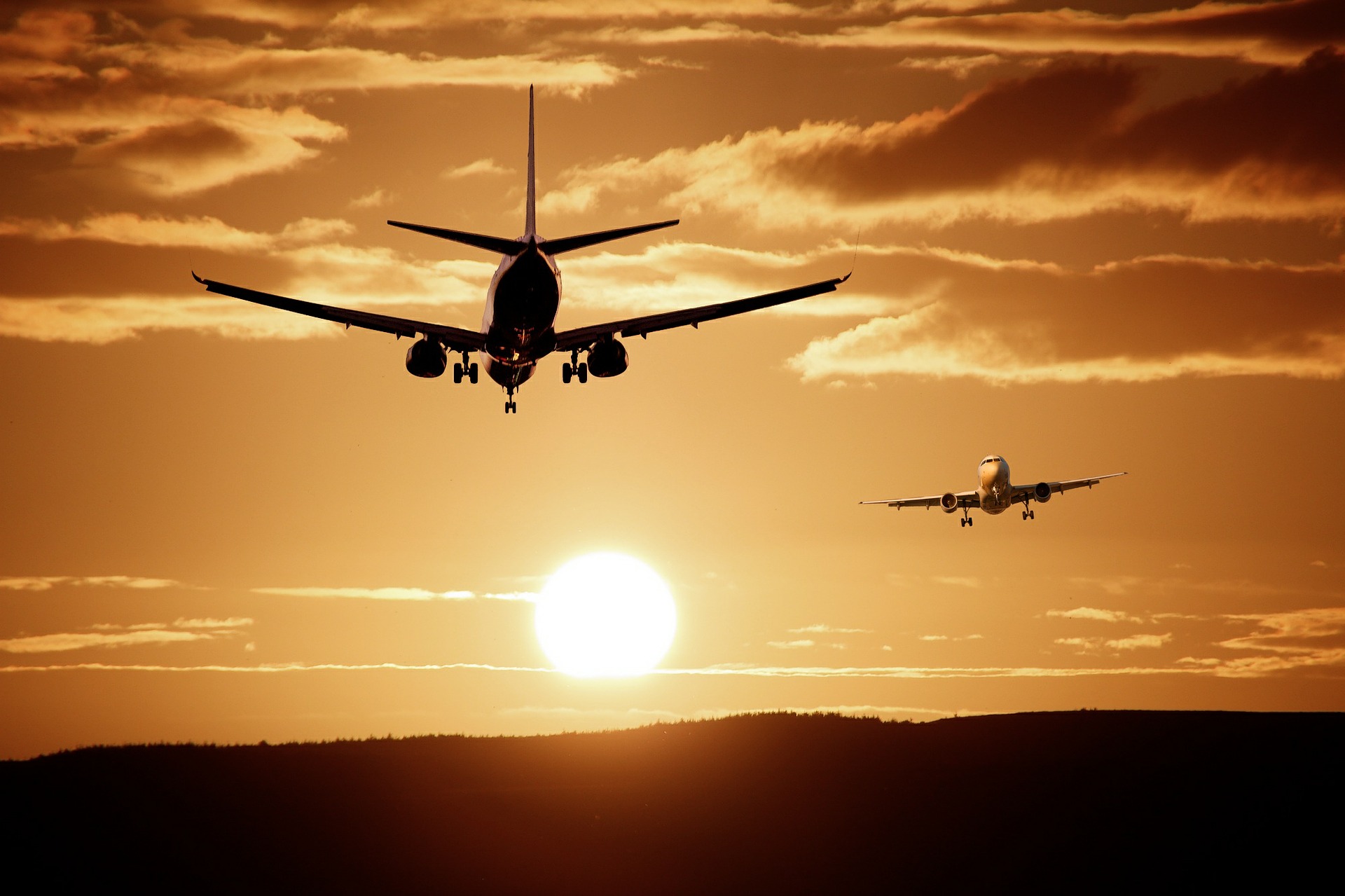 two planes landing at dusk